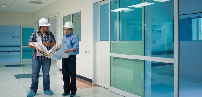 two people standing outside the automatic hospital door